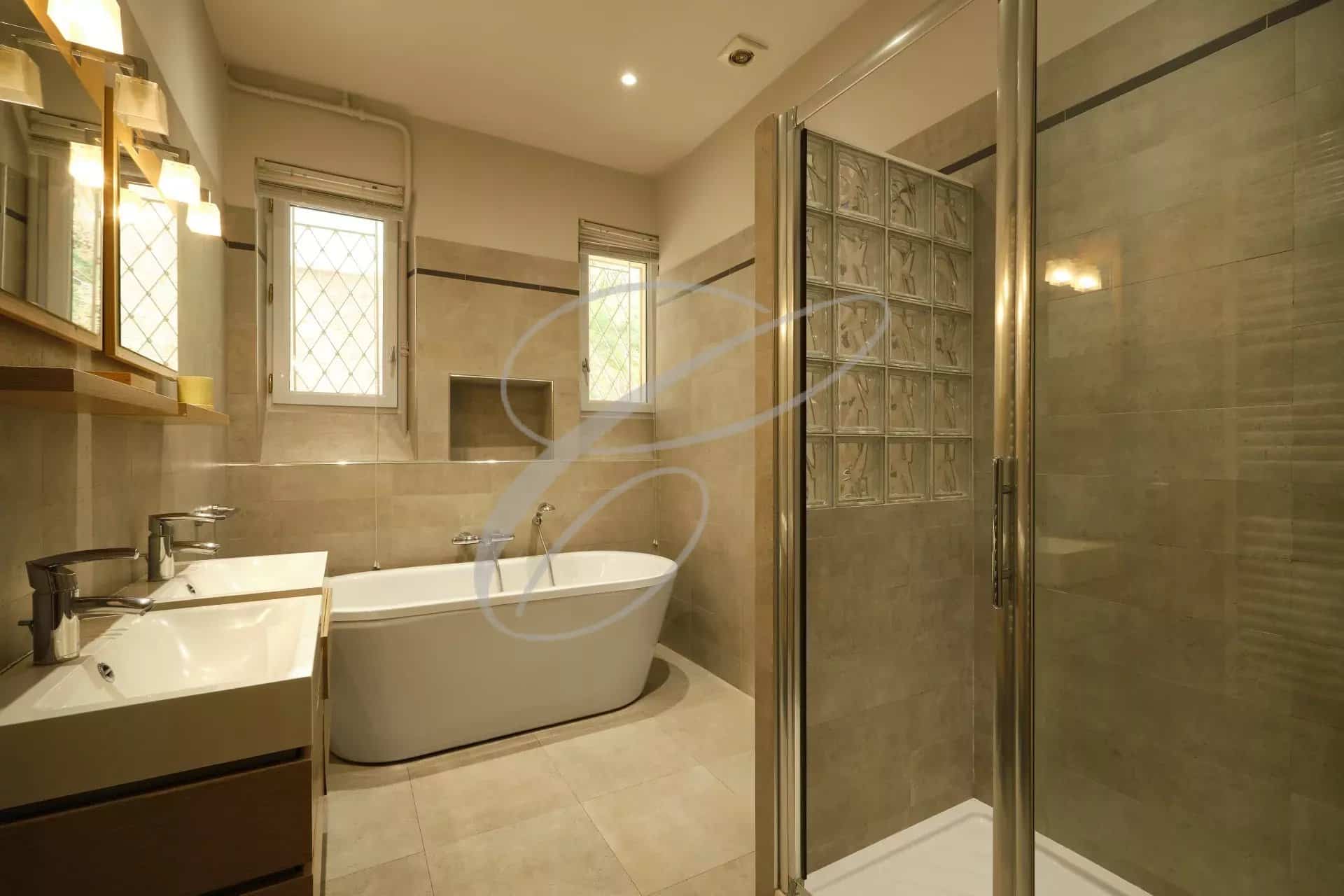 Modern bathroom with bathtub, shower and sink in an apartment in Beausoleil.