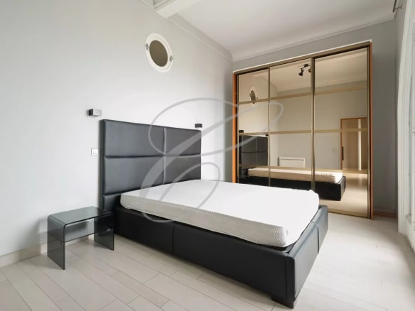 Room in a spacious apartment in Beausoleil with bed and mirror.