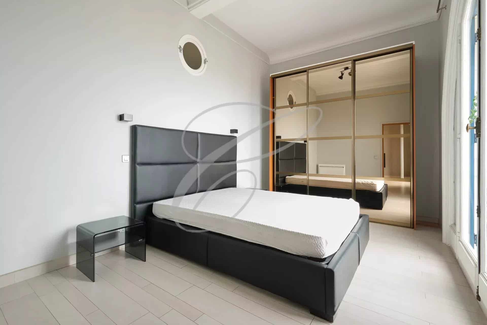 Room in a spacious apartment in Beausoleil with bed and mirror.