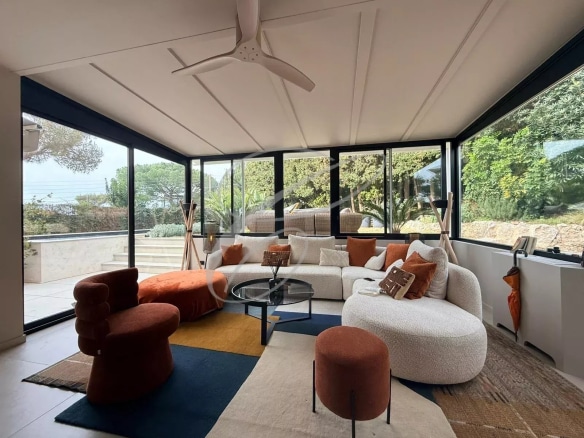 Intérieur d'un appartement rénové avec un salon lumineux et moderne, donnant sur un jardin.