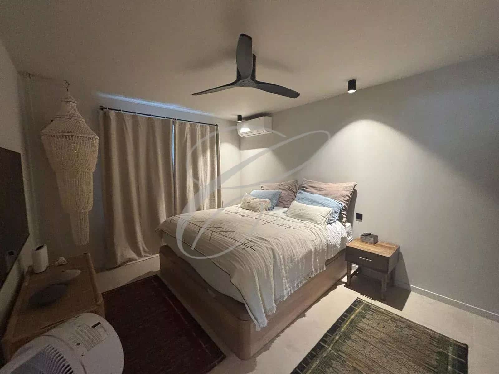 Chambre d'un appartement rénové avec lit double et décoration moderne.