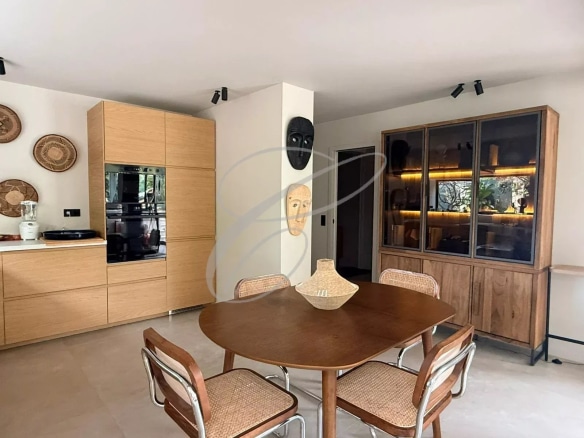 Intérieur d'un appartement rénové avec salle à manger, cuisine équipée et décoration moderne.