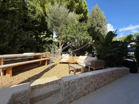 Jardin privatif d'un appartement à Roquebrune-Cap-Martin avec mobilier de jardin et végétation.