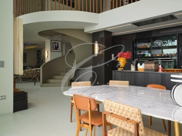 Interior of a contemporary villa with dining room and modern staircase.