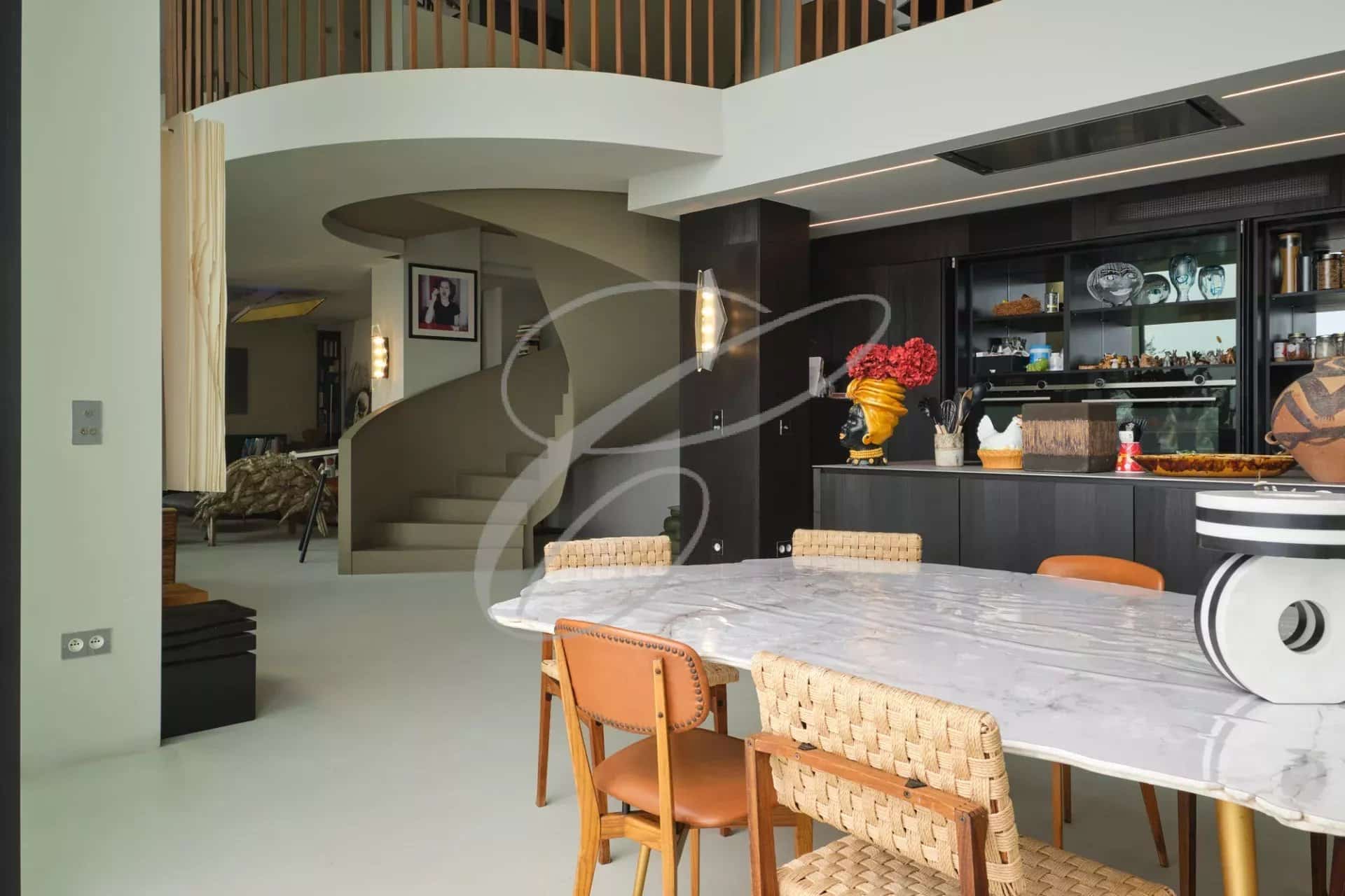 Interior of a contemporary villa with dining room and modern staircase.