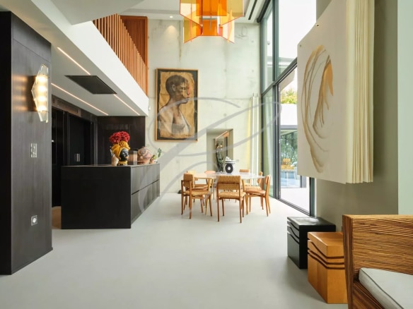 Interior of a contemporary villa with open kitchen and dining room, large bay windows.