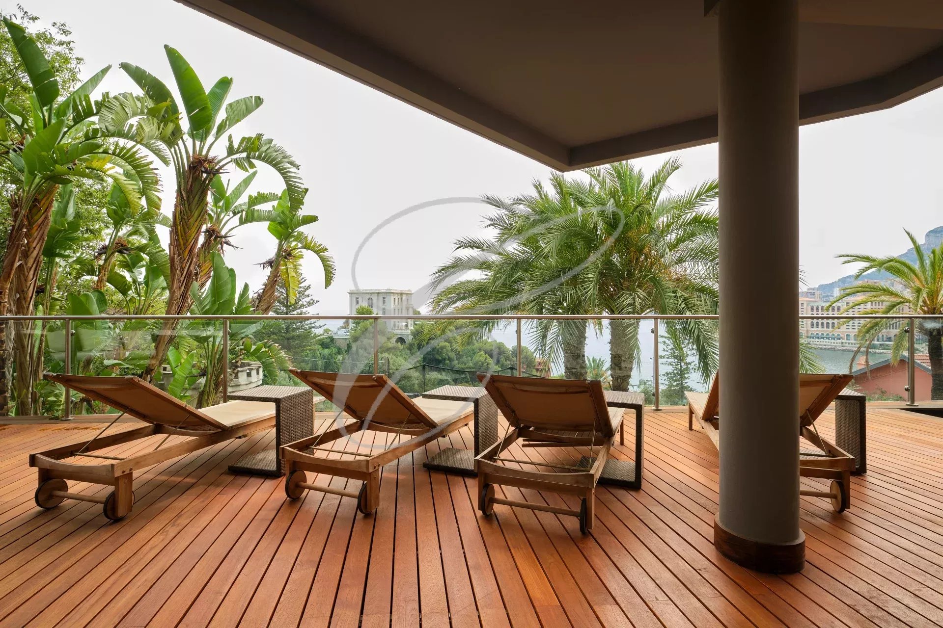 Terrasse d'une villa contemporaine avec chaises longues et vue sur la végétation luxuriante.