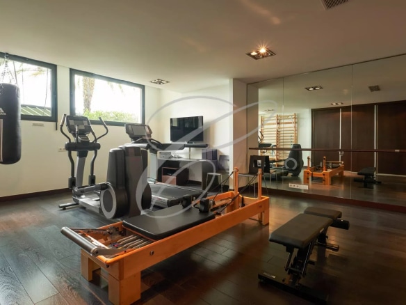 Salle de sport moderne avec équipements de fitness dans une villa contemporaine.