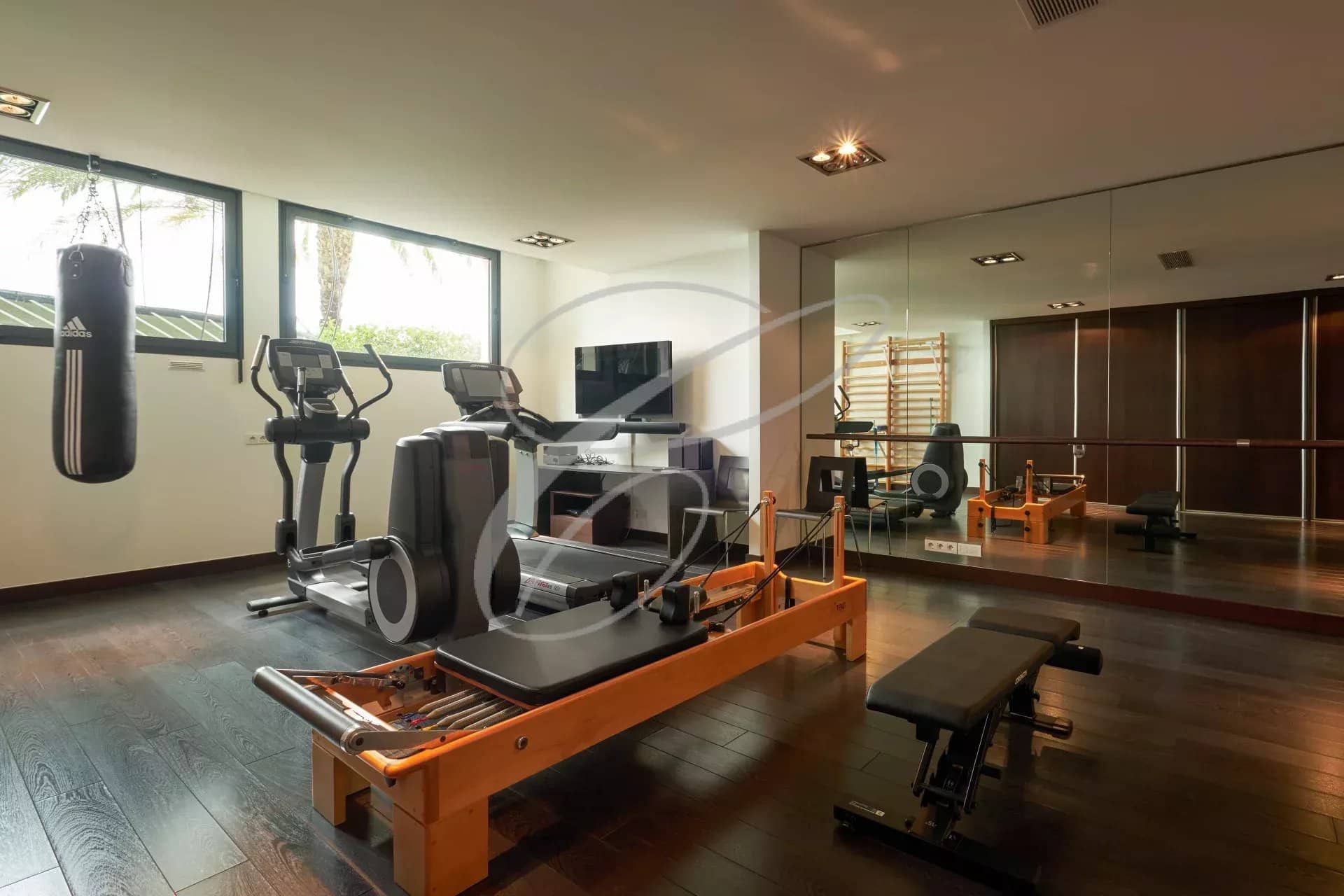 Salle de sport moderne avec équipements de fitness dans une villa contemporaine.