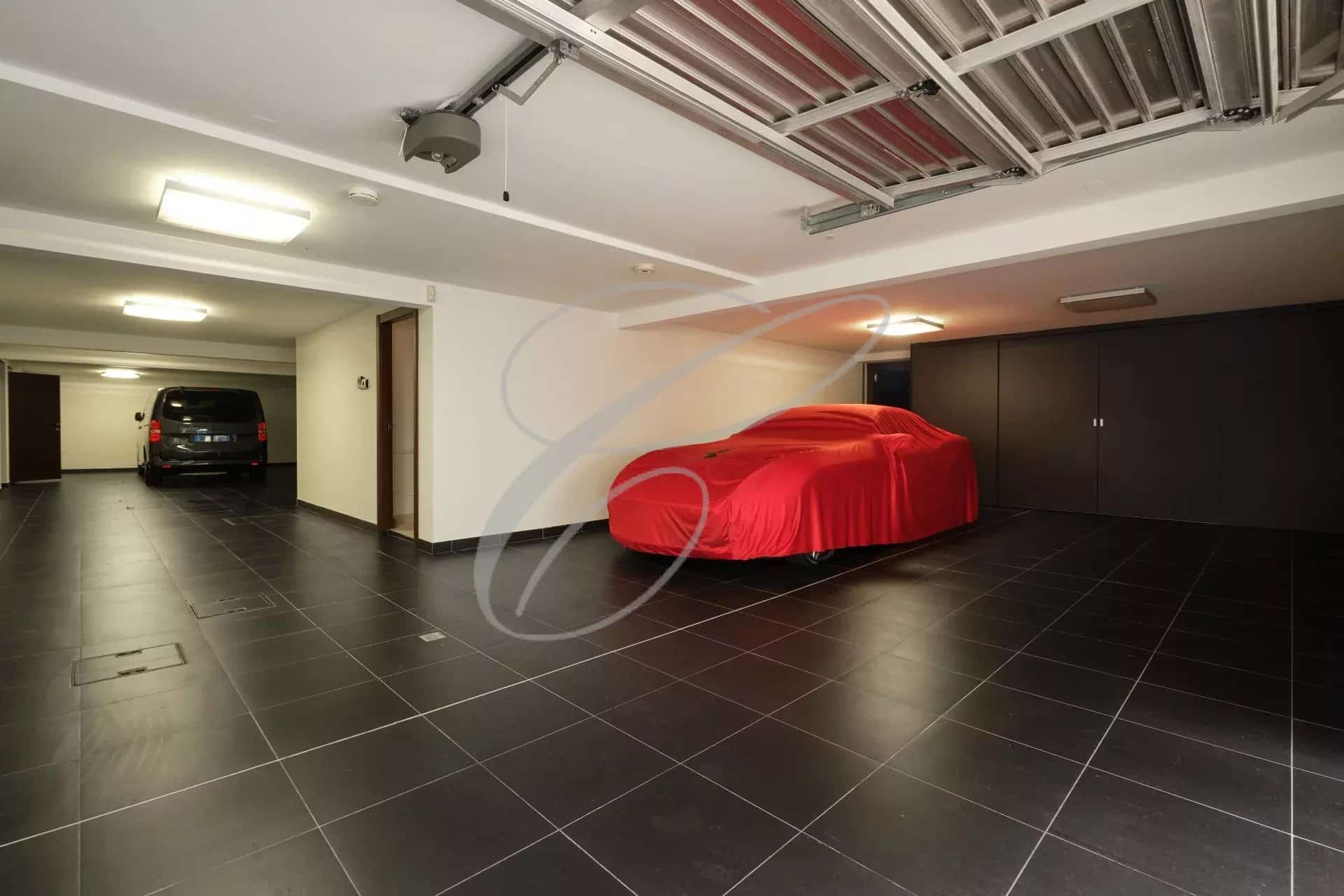 Garage spacieux avec une voiture recouverte et un espace de stationnement à Roquebrune-Cap-Martin.