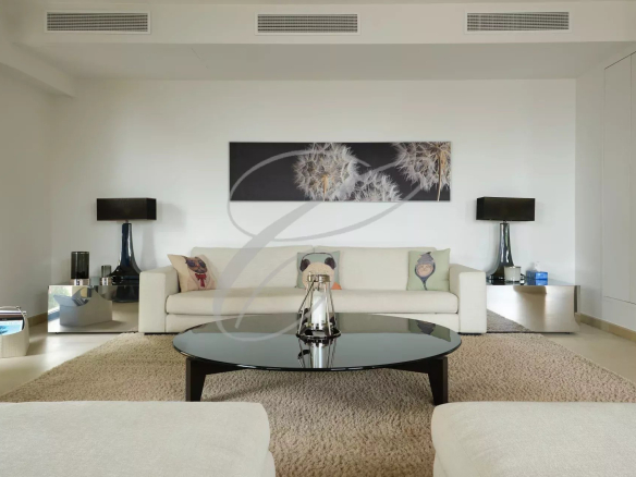 Intérieur d'une villa contemporaine avec un salon moderne, canapé, table basse et décor minimaliste.