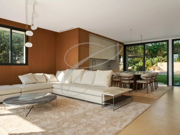Interior of a luxury villa with living room and dining room, overlooking the garden and pool.