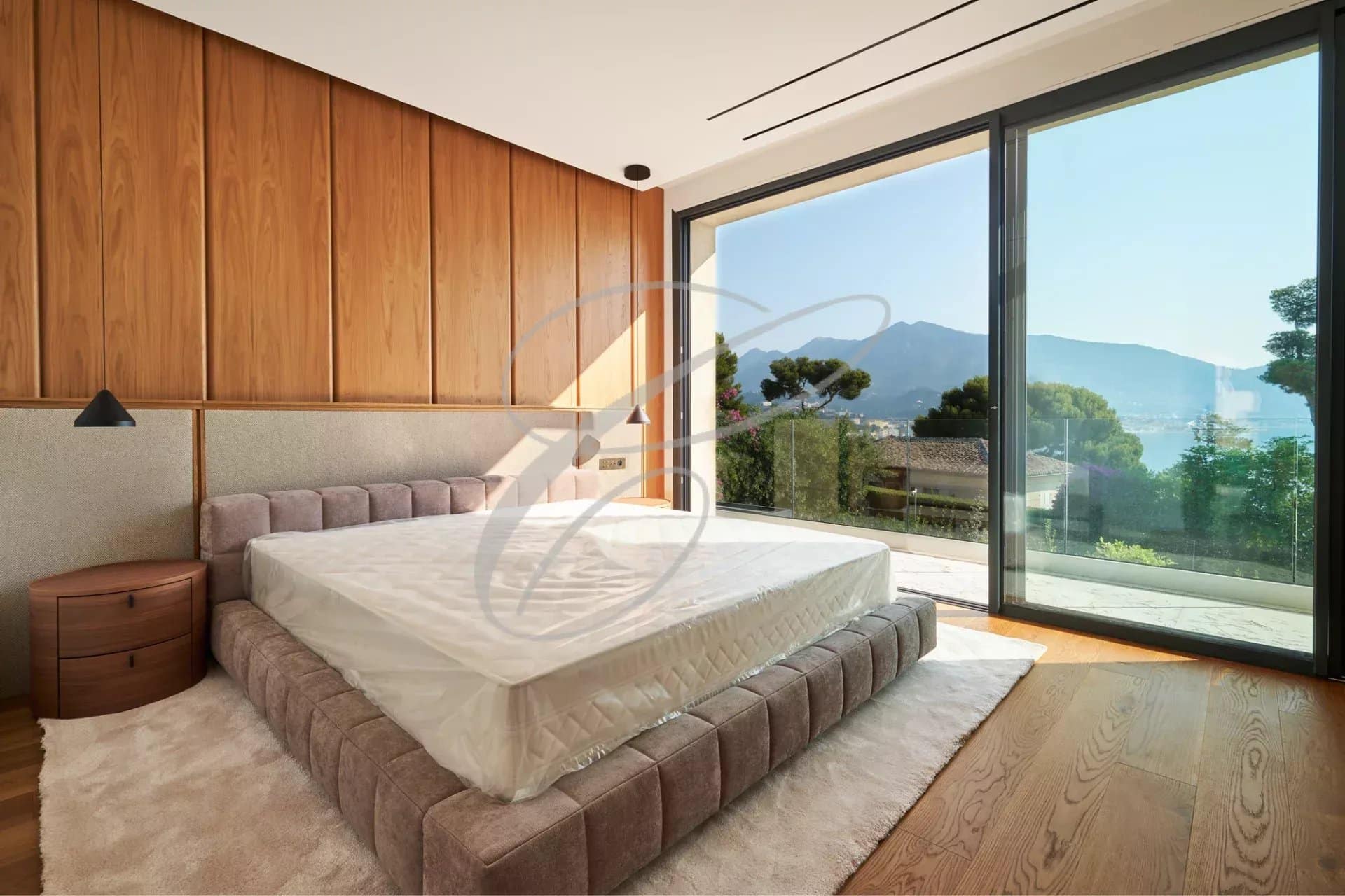 Luxury room in Cap Martin Modern room with bed and large window offering a view of the garden and the sea.
