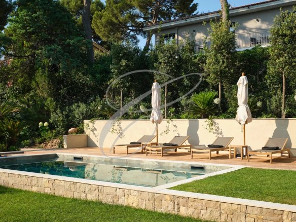 Luxuriously renovated villa with swimming pool and sun loungers in a green garden in Roquebrune-Cap-Martin.