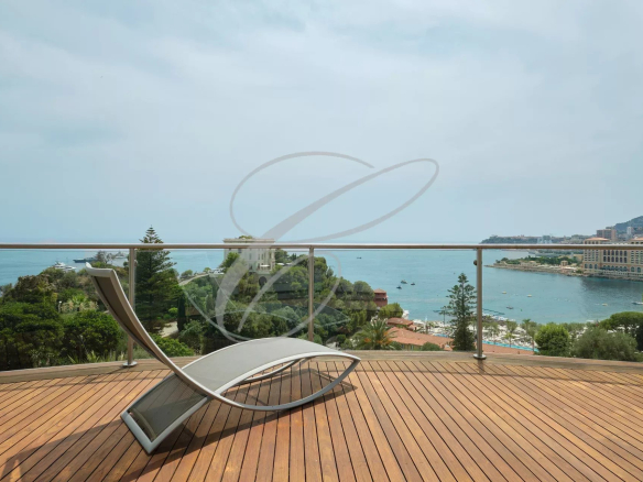 Terrasse en bois avec chaise longue surplombant la mer à Roquebrune-Cap-Martin.