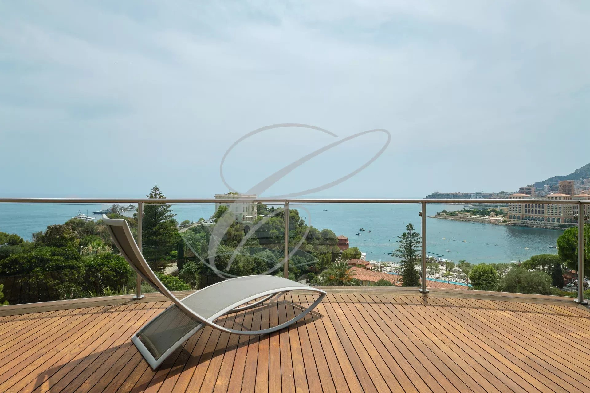 Terrasse en bois avec chaise longue surplombant la mer à Roquebrune-Cap-Martin.