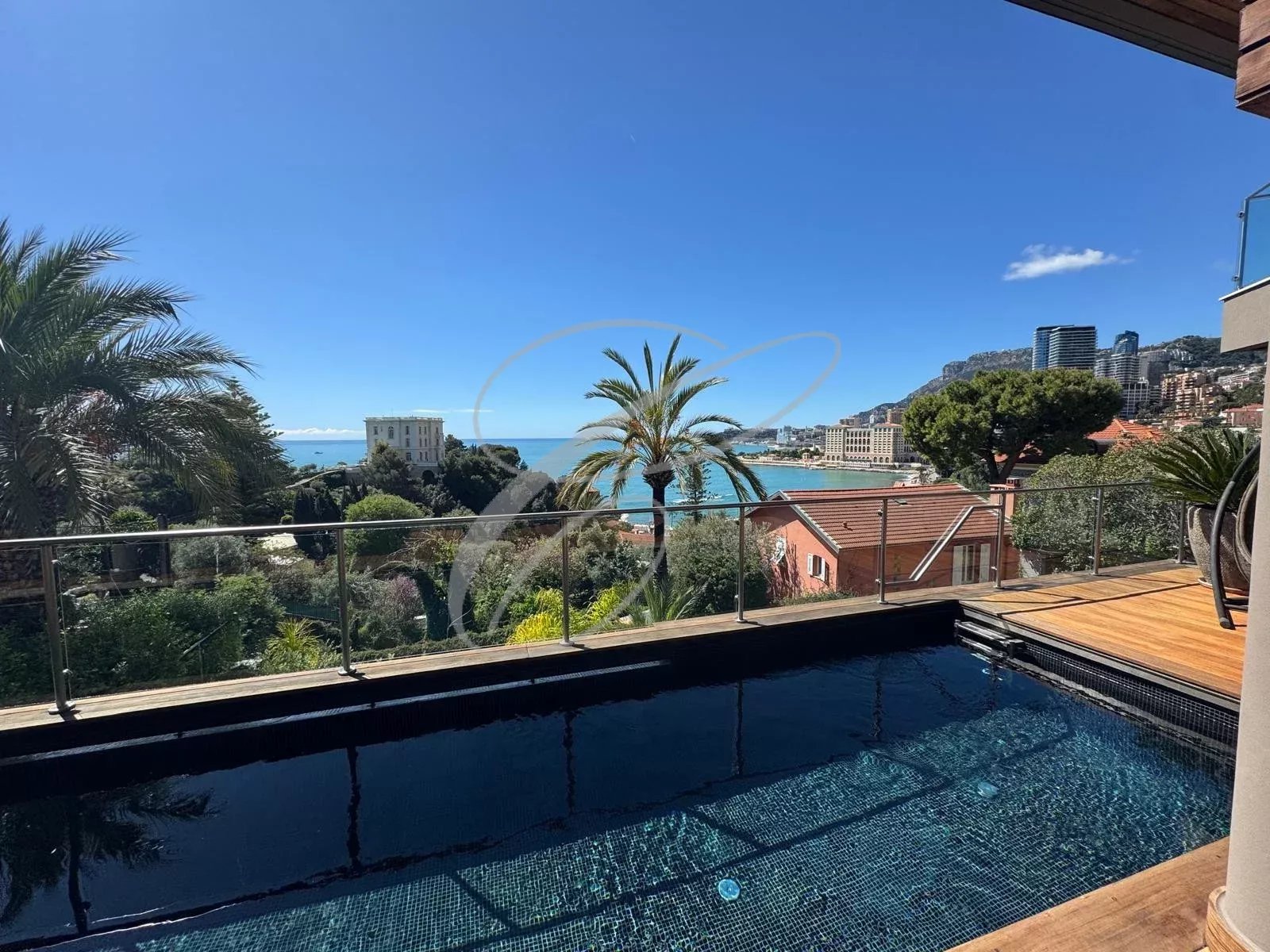 Vue de la piscine d'une villa contemporaine avec mer en arrière-plan à Roquebrune-Cap-Martin.