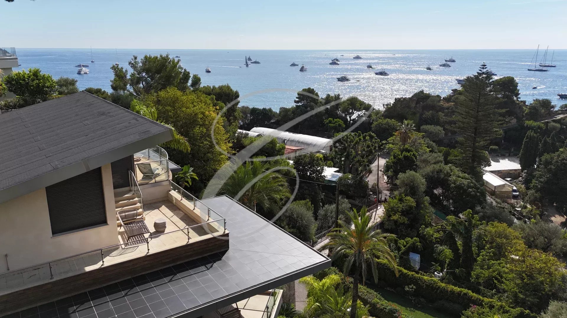 Vue aérienne d'une villa contemporaine à Roquebrune-Cap-Martin avec la mer en arrière-plan.