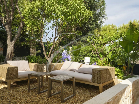 Outdoor space of an apartment with garden furniture and lush vegetation.