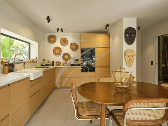 Modern kitchen with dining table in a renovated apartment in Roquebrune-Cap-Martin.