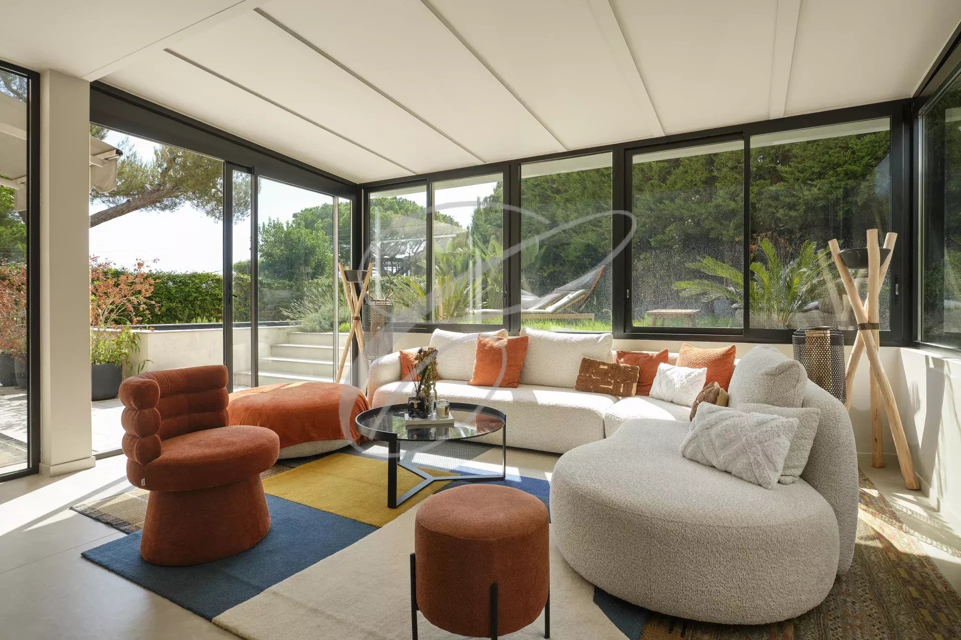 Renovated apartment living room in Roquebrune-Cap-Martin Bright living room of a renovated apartment with windows overlooking a garden, modern and colorful furniture.