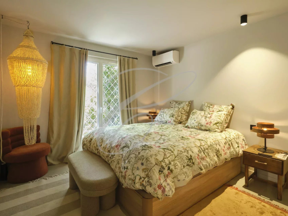 Room in a renovated apartment with a double bed, floral decor and access to the outside.