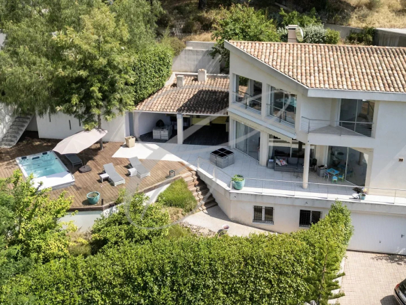 Villa moderne avec vue mer à Roquebrune-Cap-Martin, entourée de verdure et avec terrasse.