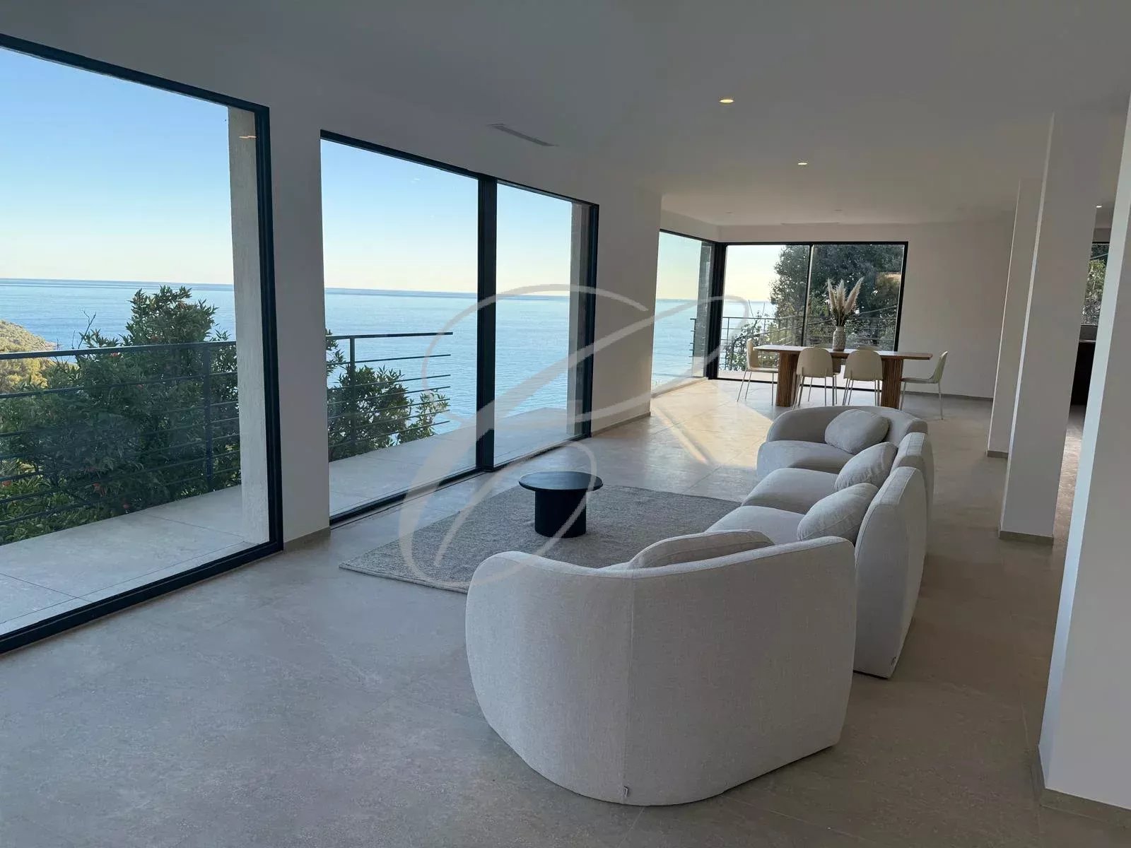 Intérieur d’une villa à Roquebrune-Cap-Martin Intérieur d'une villa moderne avec vue sur la mer, salon lumineux et ouvert.