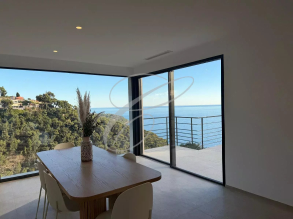 Intérieur d'une villa rénovée avec vue mer à Roquebrune-Cap-Martin, salle à manger lumineuse.
