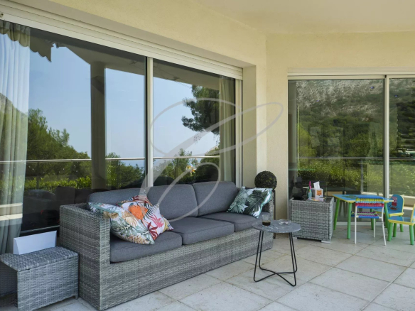 Terrasse d'une villa moderne avec mobilier de jardin et vue sur la nature à Roquebrune-Cap-Martin.
