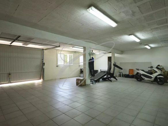 Intérieur d'un garage spacieux avec équipements de fitness et véhicules à Roquebrune-Cap-Martin.