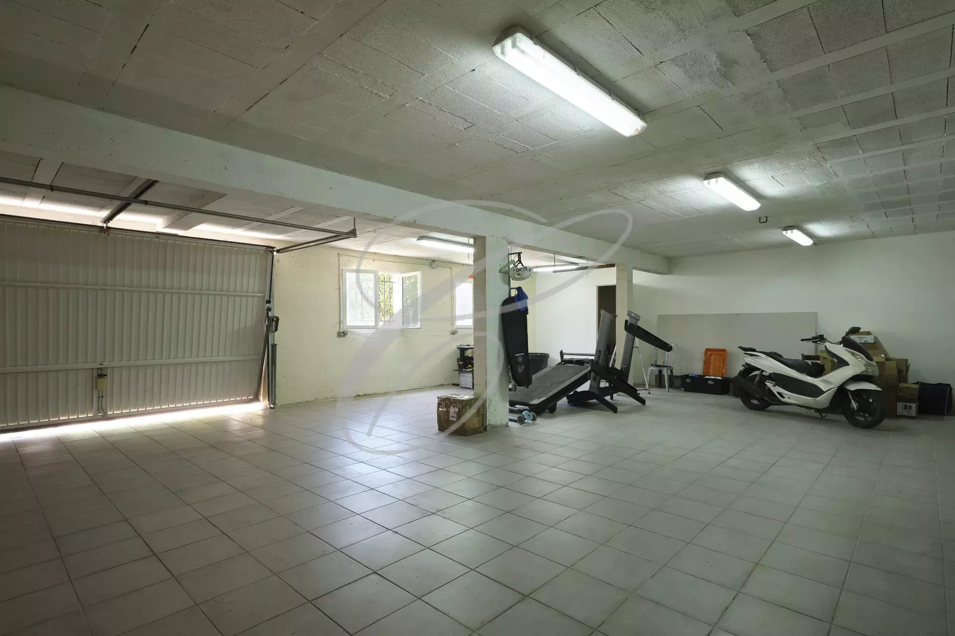 Garage spacieux à Roquebrune-Cap-Martin Intérieur d'un garage spacieux avec équipements de fitness et véhicules à Roquebrune-Cap-Martin.