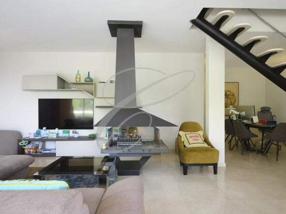 Intérieur d'une villa moderne avec cheminée, salon et bureau.
