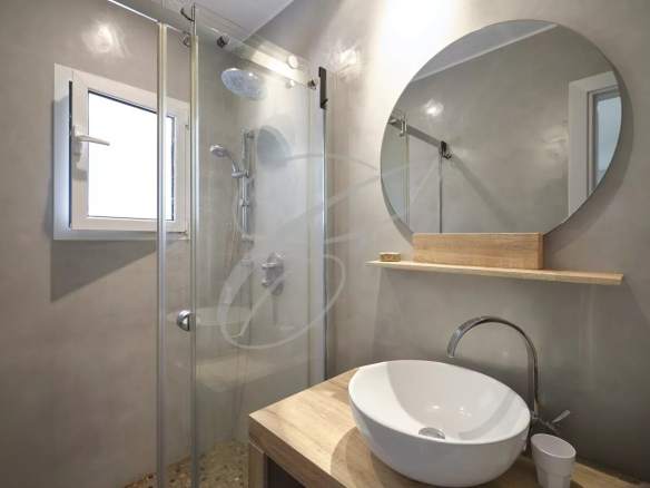 Salle de bain moderne avec douche en verre et lavabo design.