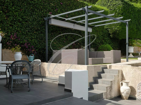 Terrace of a villa in Roquebrune-Cap-Martin with outdoor furniture and stone staircase.