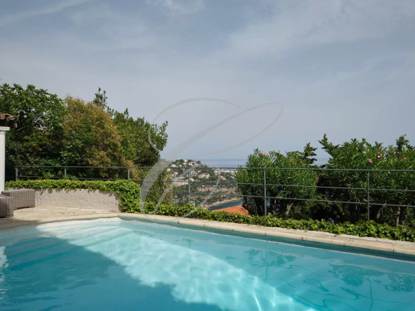 View from the swimming pool of a villa with garden in Roquebrune-Cap-Martin, panoramic view of the sea.