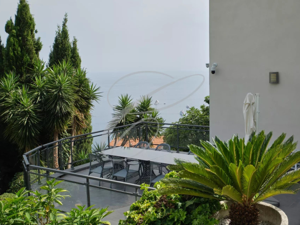 View of the villa with pool and garden in Roquebrune-Cap-Martin, sea view in the background.