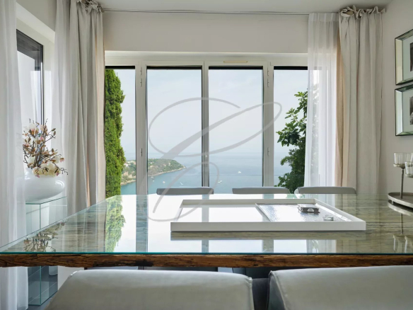 Interior view of a villa in Roquebrune-Cap-Martin with a glass table and sea view.