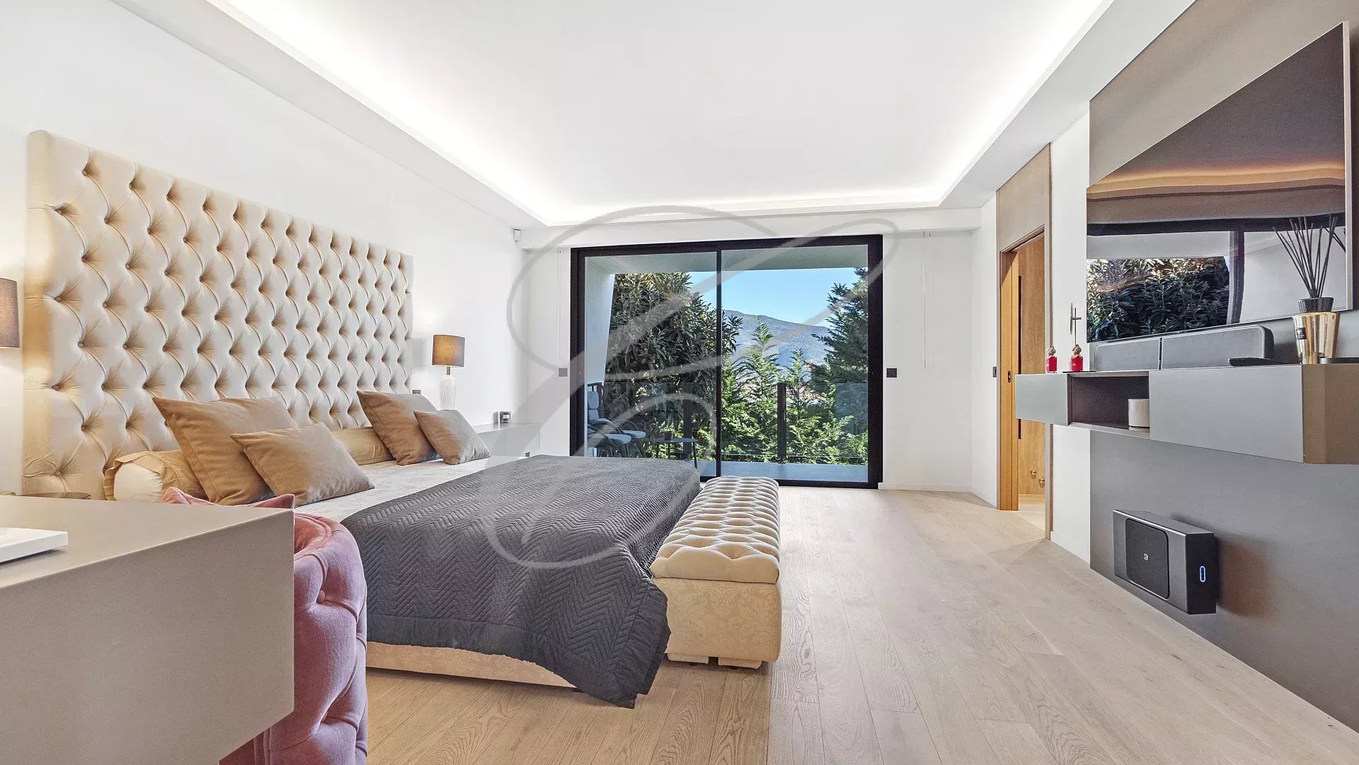 Chambre moderne avec lit king size et vue sur un jardin paysager.