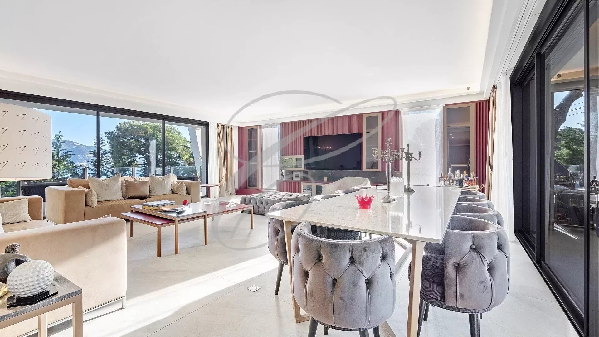 Intérieur d'une villa contemporaine avec salon spacieux et vue sur la mer.
