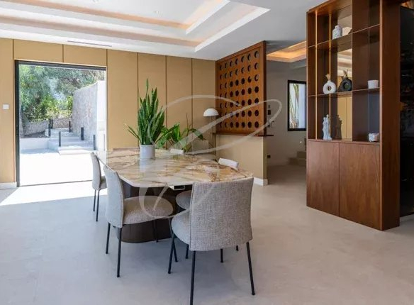 Intérieur d'une villa contemporaine à Beausoleil avec salle à manger et accès à l'extérieur.