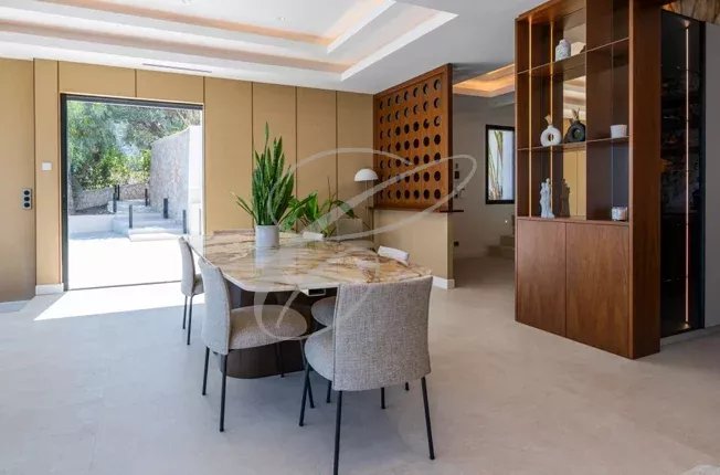 Intérieur d'une villa contemporaine à Beausoleil avec salle à manger et accès à l'extérieur.