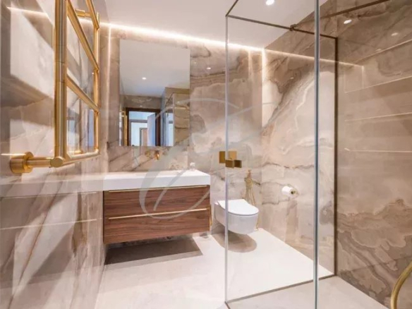 Salle de bains moderne avec douche en verre et meuble en bois dans une villa contemporaine.