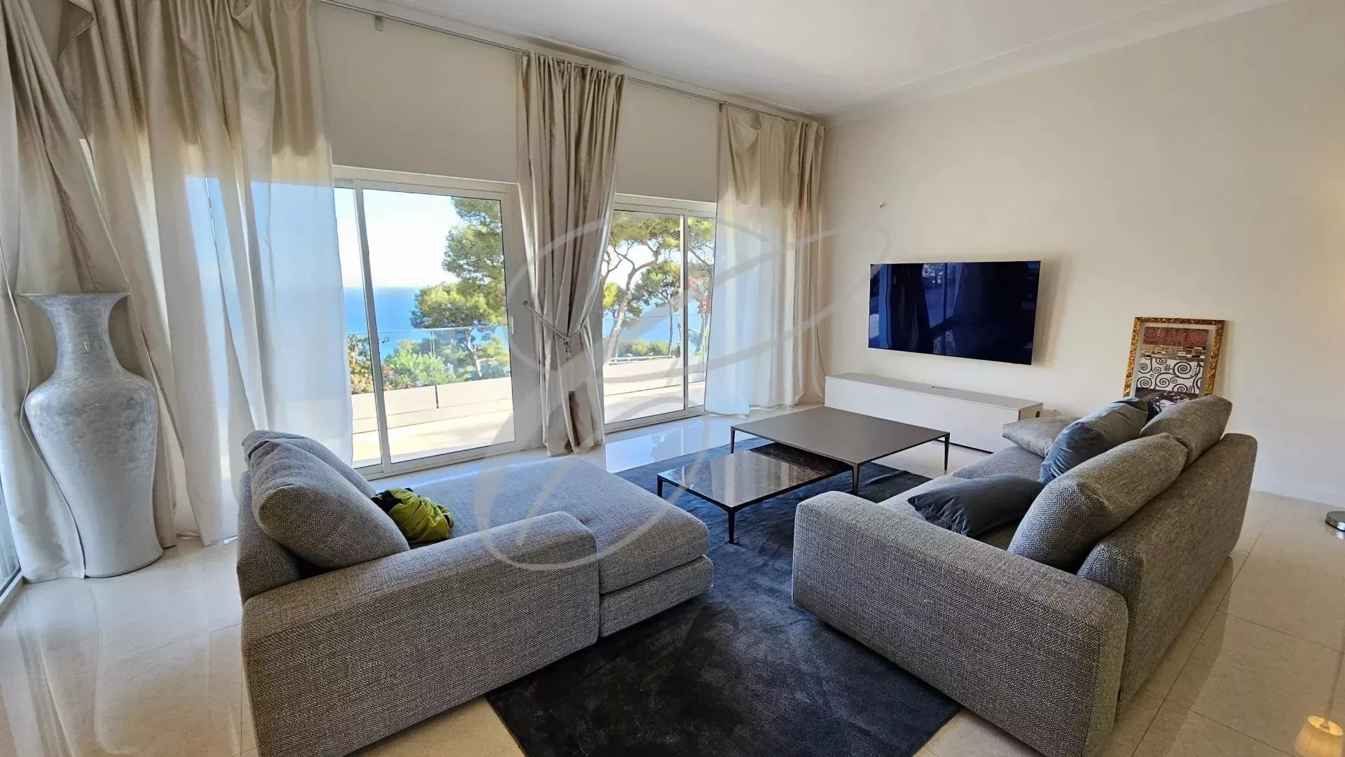 Intérieur d'une villa à Èze avec vue sur la mer, salon lumineux et moderne.
