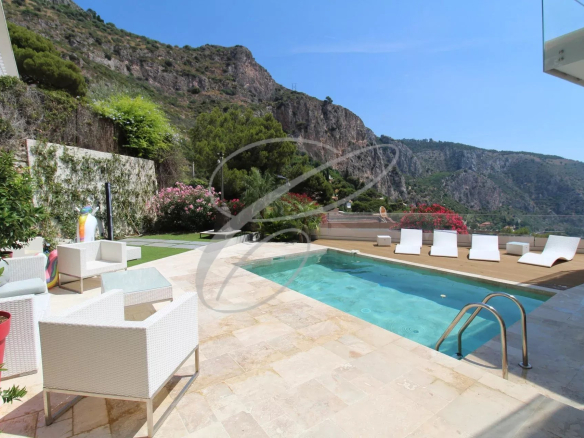 Villa avec piscine et chaises longues, vue sur les montagnes à Èze.