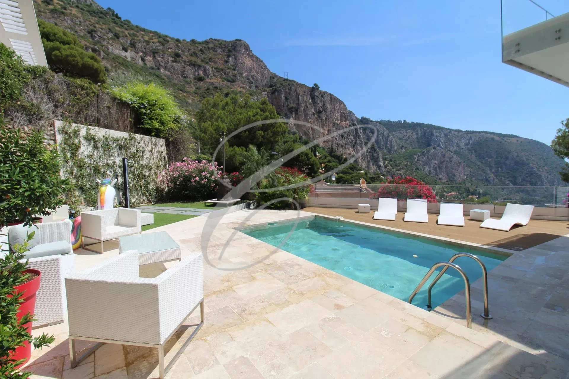 Villa avec piscine et chaises longues, vue sur les montagnes à Èze.