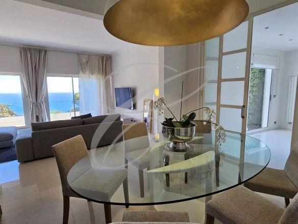 Intérieur d'une villa à Èze avec salle à manger et vue sur la mer.