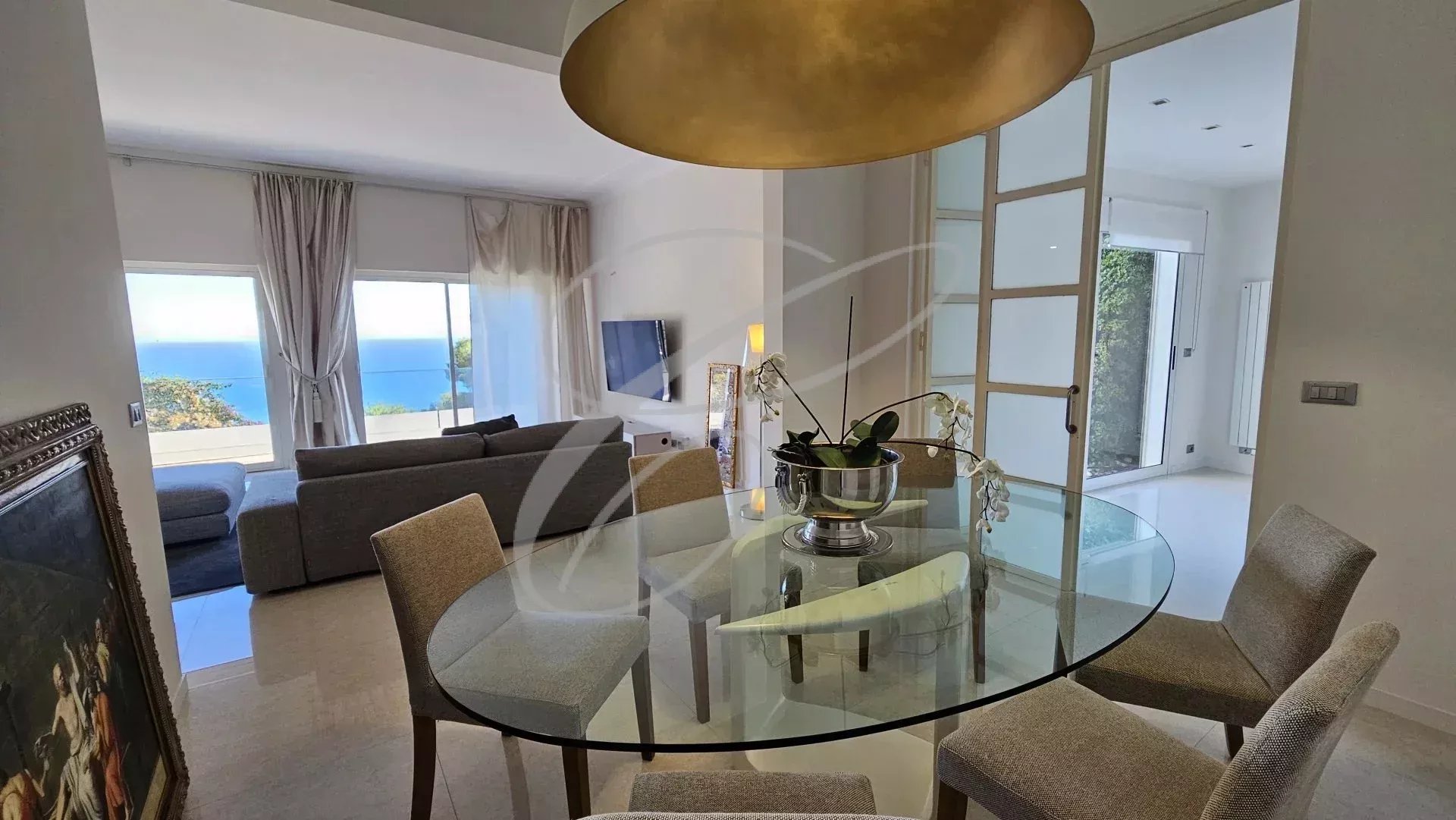 Intérieur d'une villa à Èze avec salle à manger et vue sur la mer.