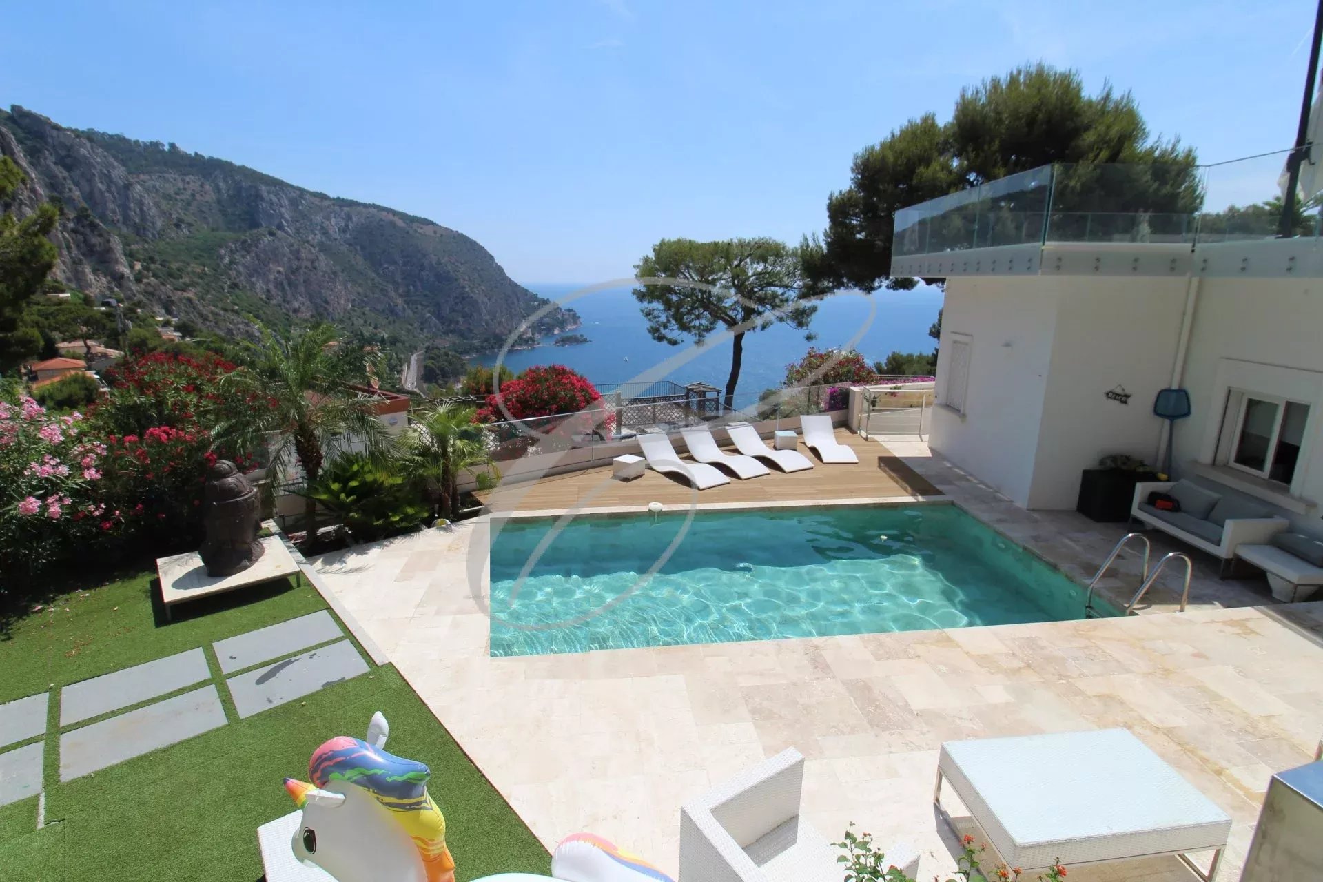 Villa avec piscine et vue sur la mer à Èze, entourée de verdure et de montagnes.