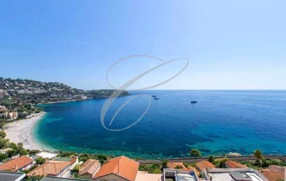 Panoramic sea view from Roquebrune-Cap-Martin with beach and hills in the background.